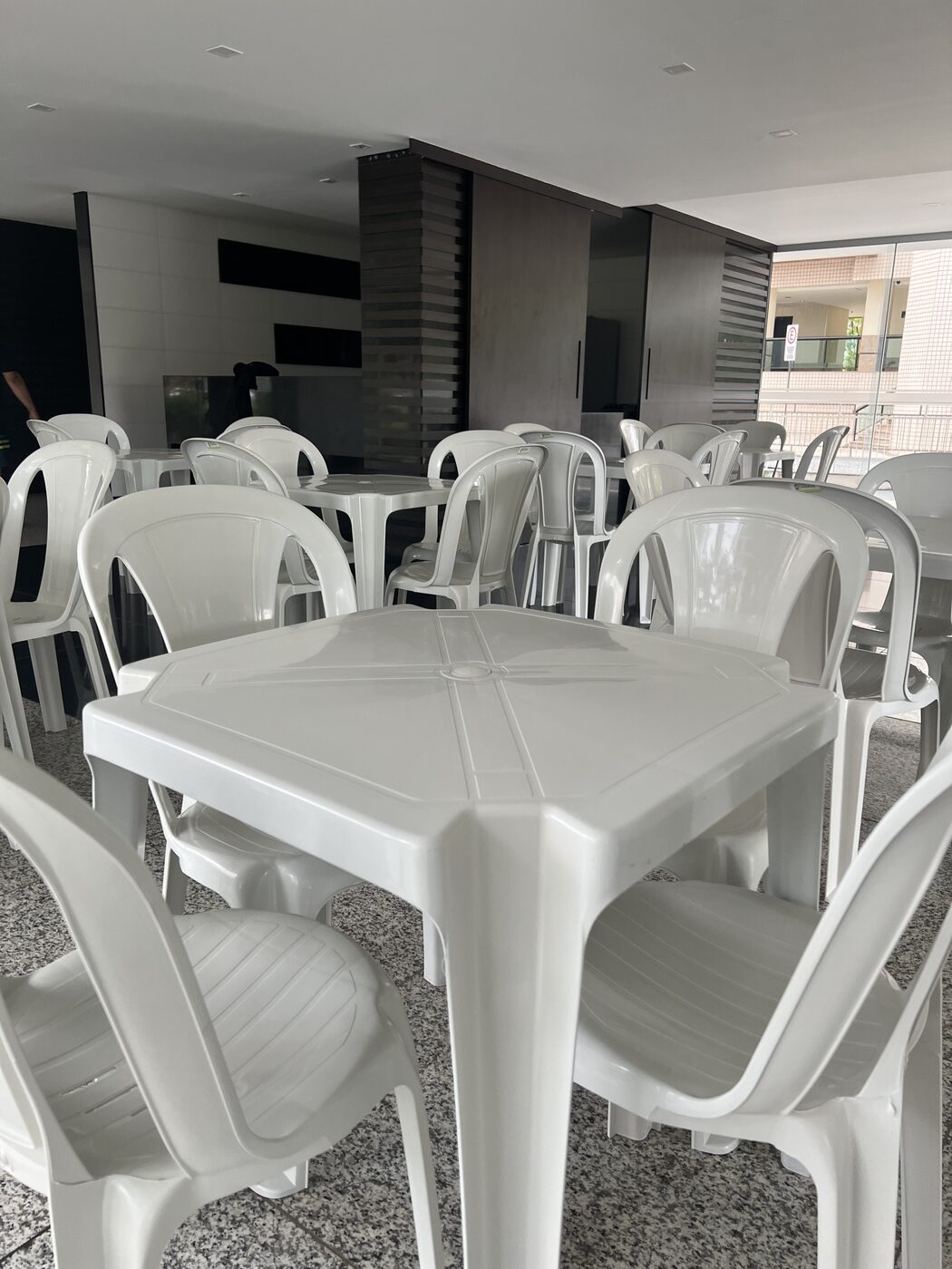 Jogos de mesa com cadeiras plásticas brancas montados para uma festa